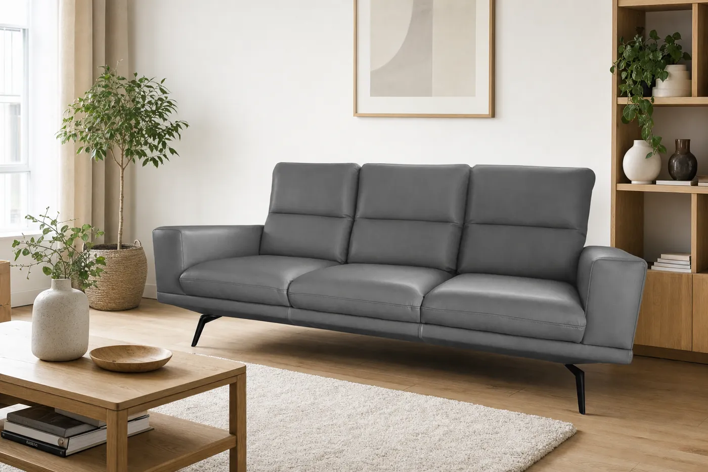 Sofa ze skóry naturalnej w jasnym salonie z drewnianym regałem